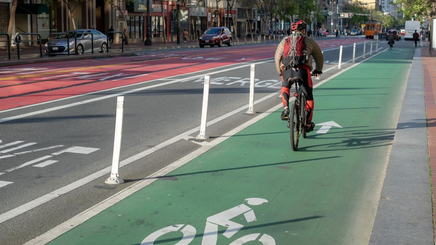 Person bicycling in separated bike lane.