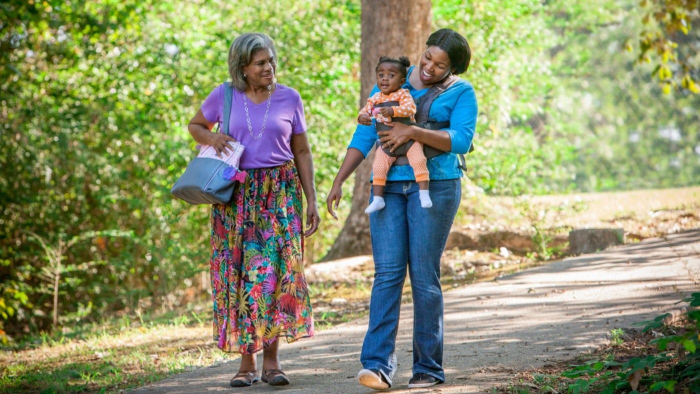 Grandmother, mother, and daughter taking a walk in the park.