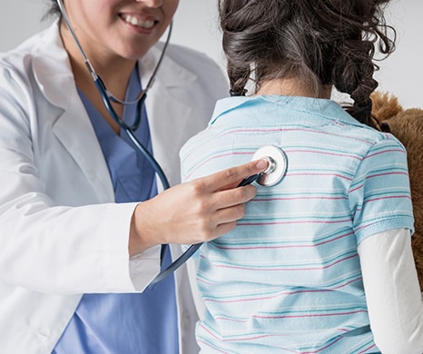 doctor with stethoscope examining young female patient