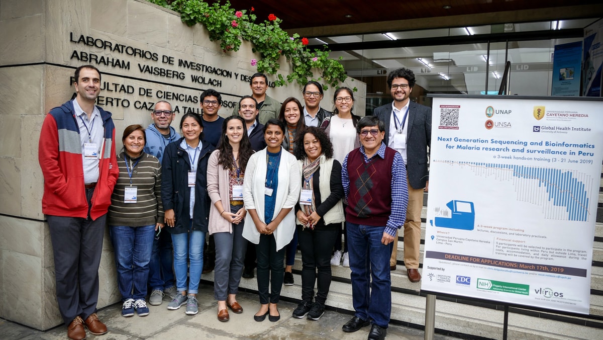 Trainers and attendees stand together outside a building with the words Laboratorio de Investigació n de Productos Naturales de la Amazonia