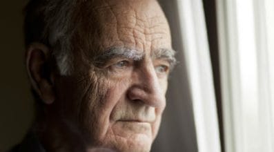 Older man looks out of a window