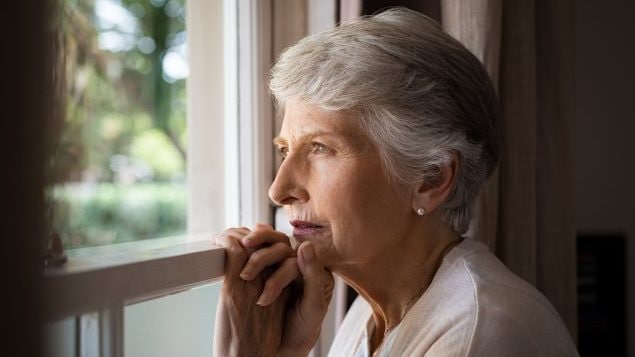 Older woman looking out a window