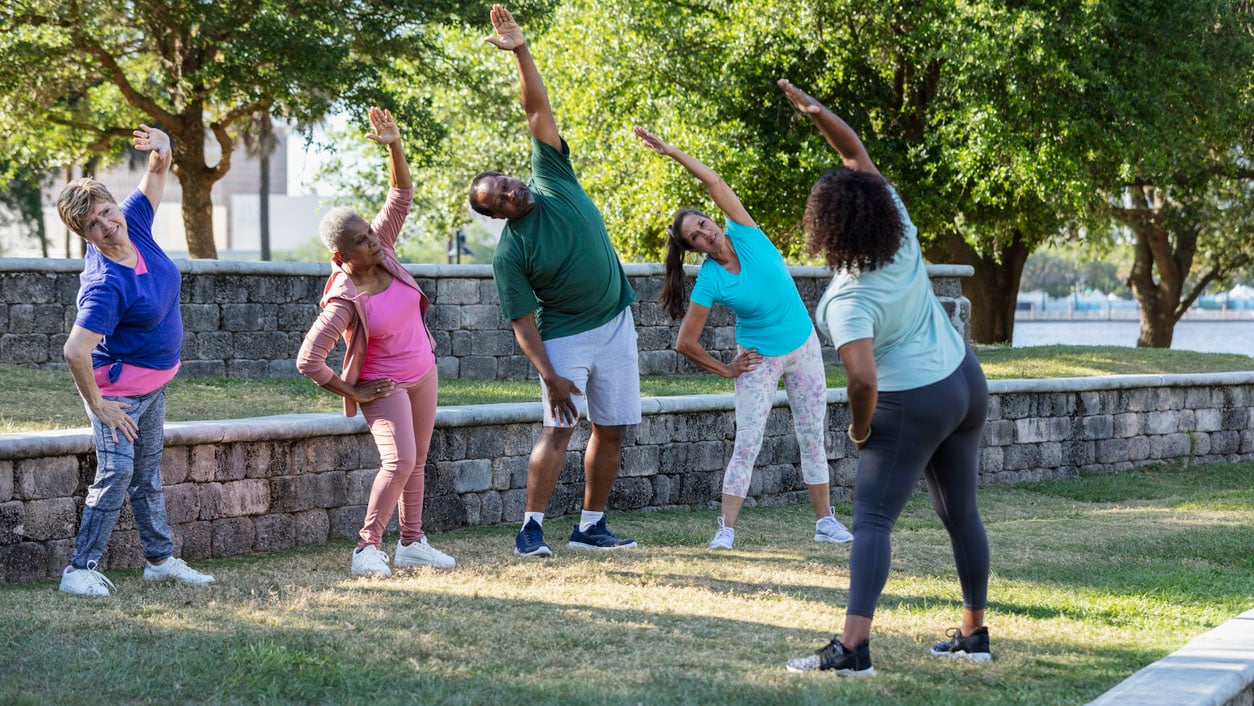 People stretching in the park as a group