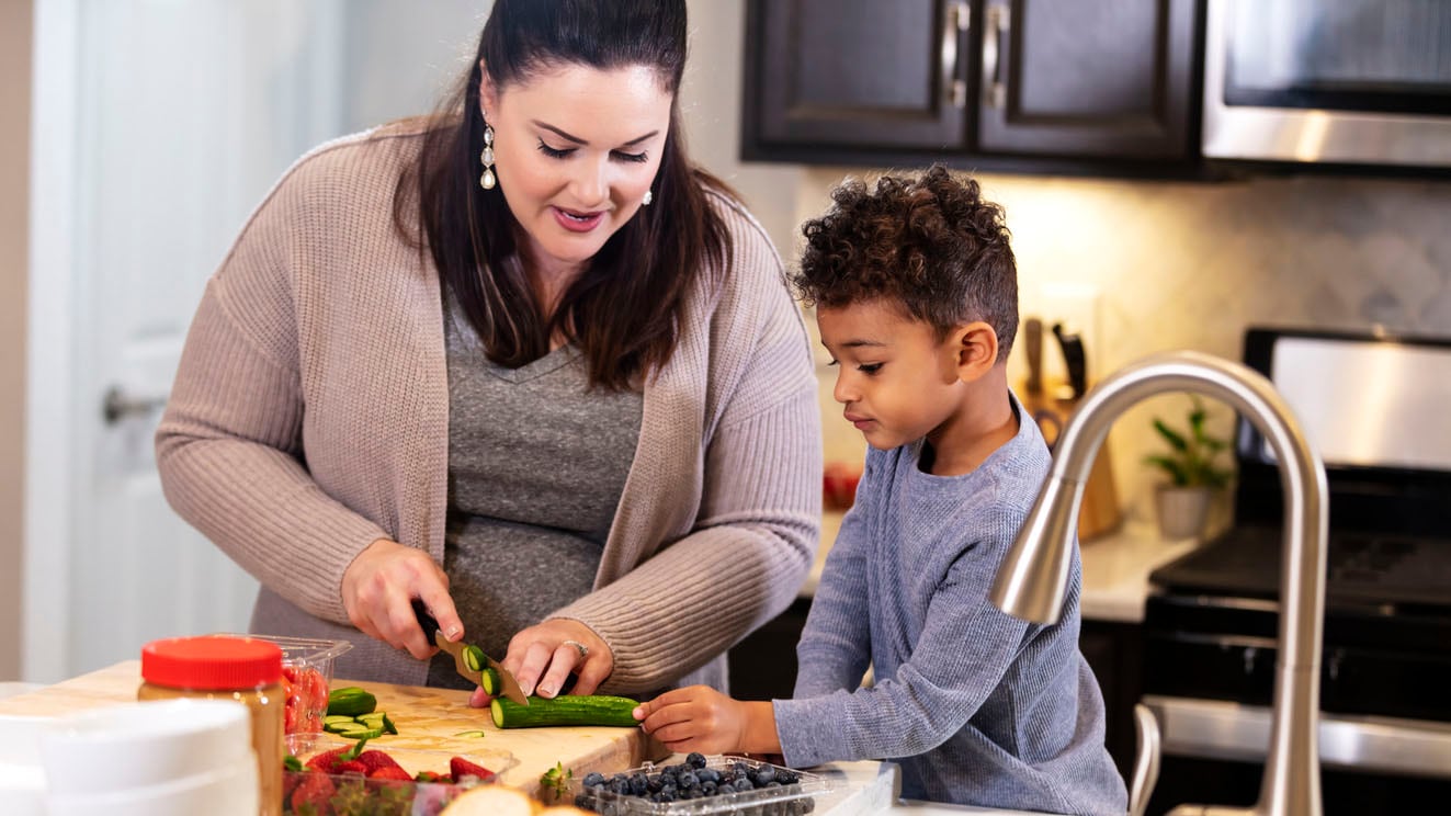 Mother and young son preparing vegetables in the kitchen