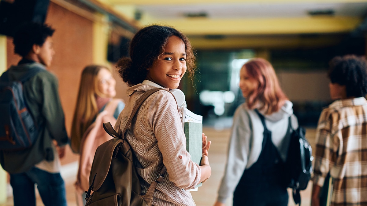 girl with backpack walking in school