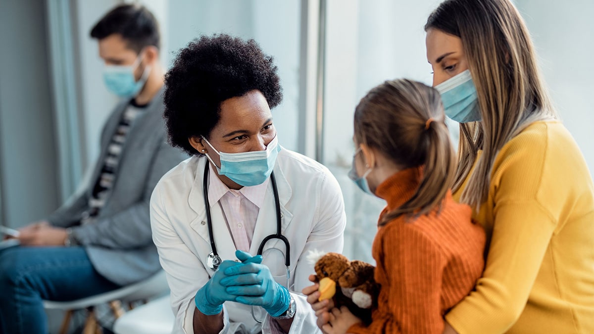 A doctor talks with a child and parent.