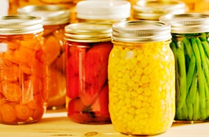 Canned vegetables, including carrots, tomatoes, corn, and green beans.