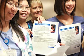 Nurse holding up mPINC questionnaires