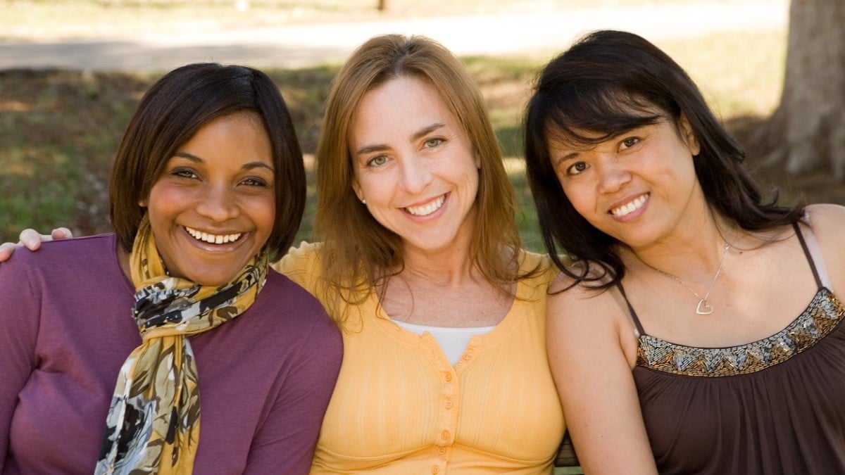 Three young women smiling