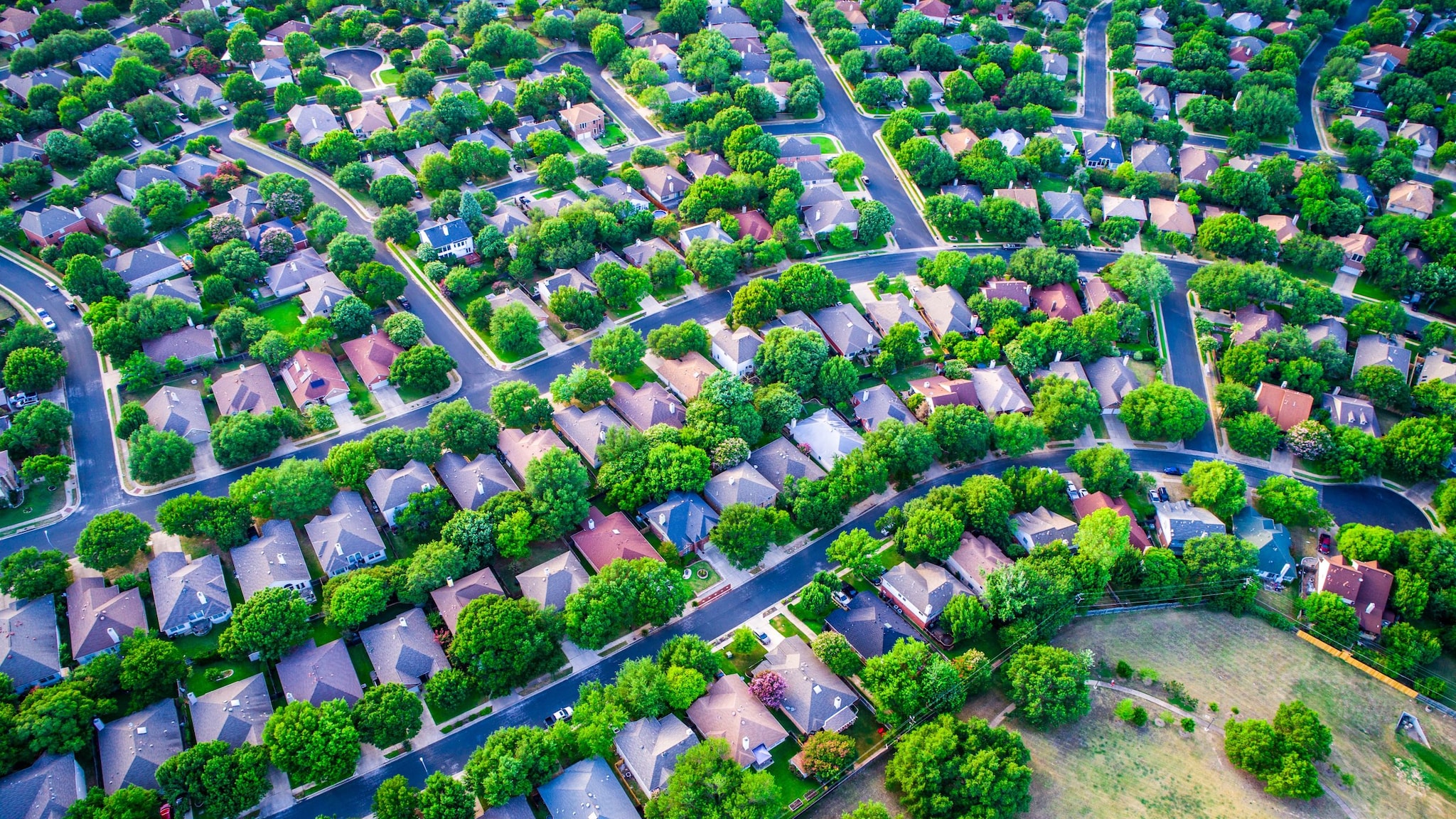 Aerial view of a  neighborhood with many houses and trees.