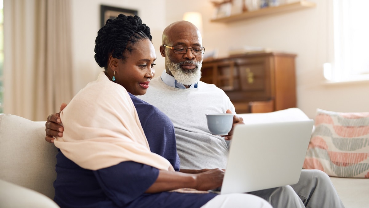 Foto de un hombre y una mujer mirando una computadora portátil