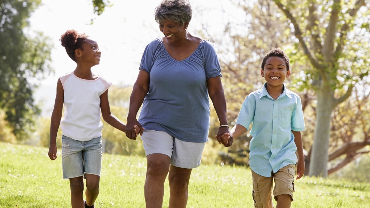 una abuela y sus dos nietos caminando afuera