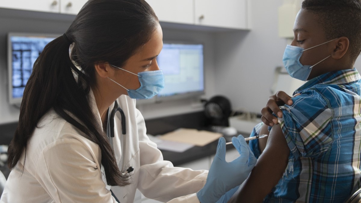 una médica aplicando una vacuna contra el VPH a un niño