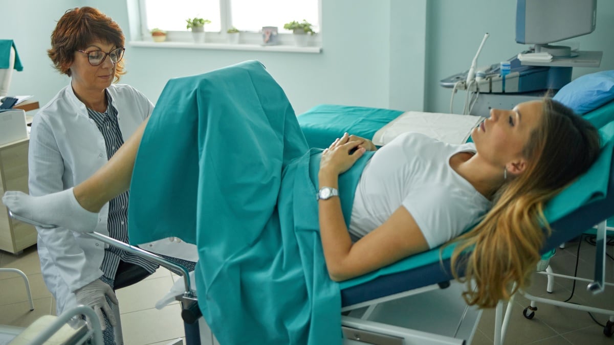 A doctor performs a cervical cancer screening test on a young woman