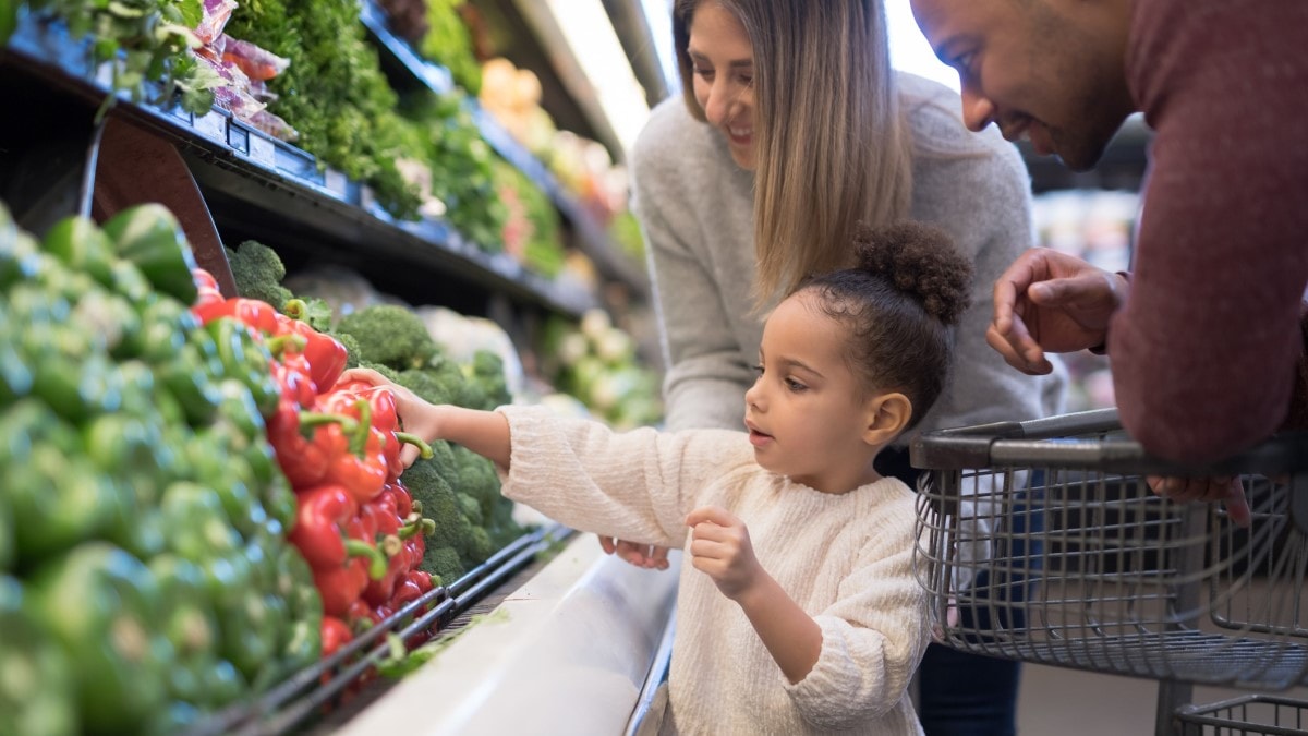 Foto de una familia comprando verduras frescas