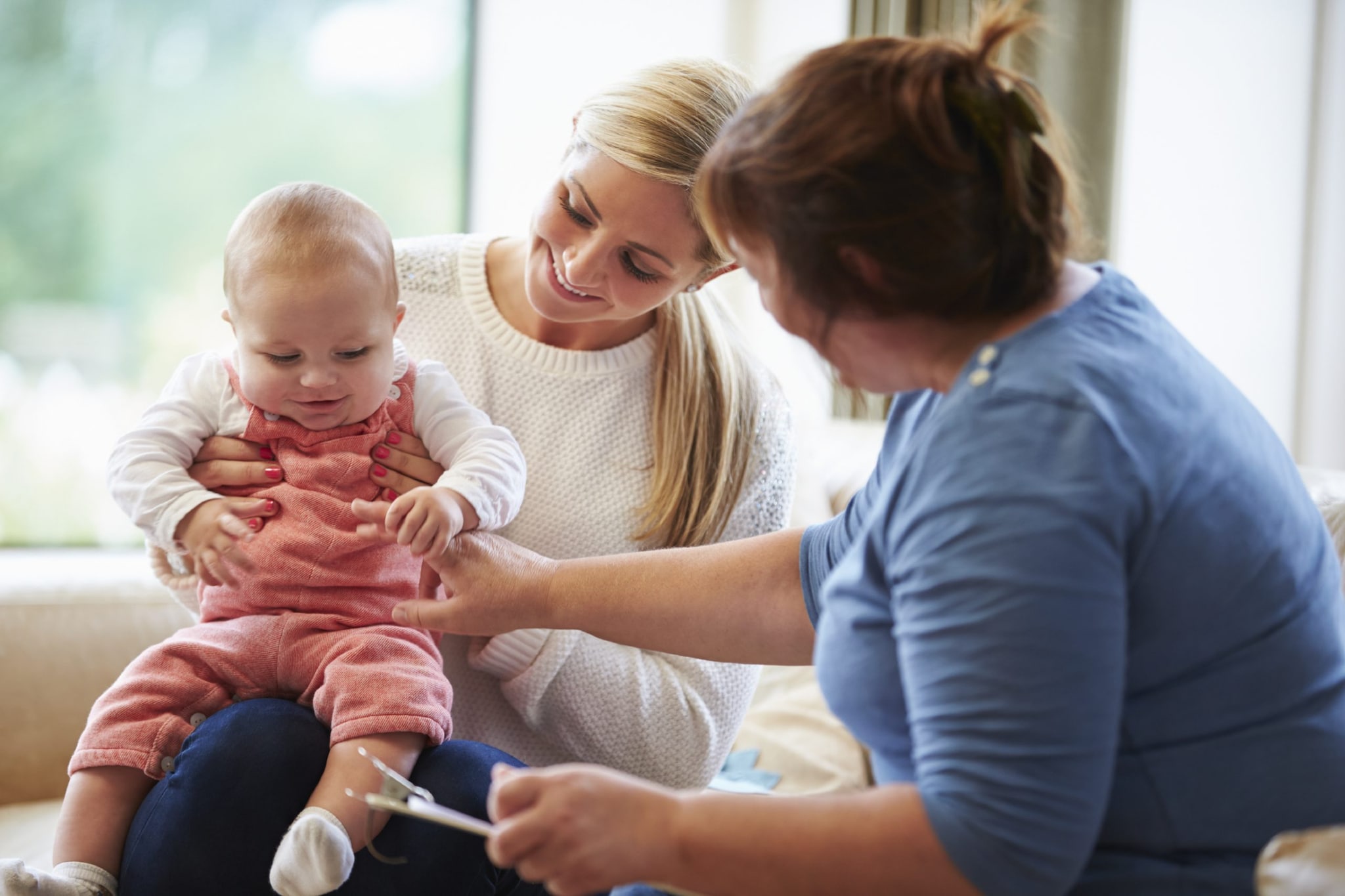 Health visitor talking to a mother with young baby