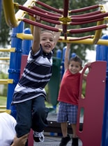 Niños jugando en área de juegos infantiles