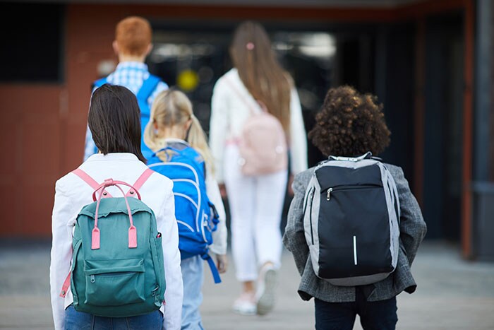 Children with backpacks headed to school