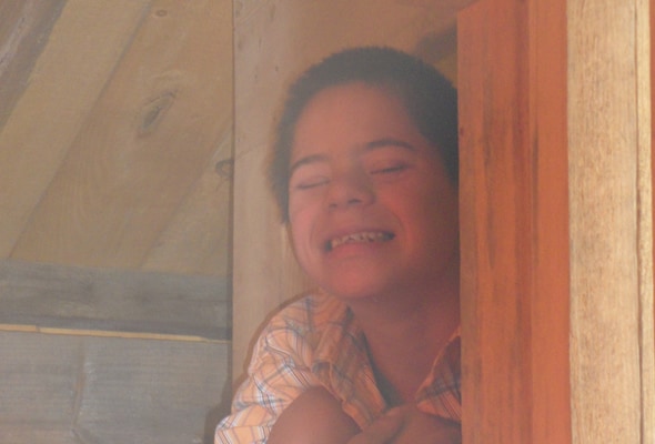 Photo of a boy hiding in a corner of a room.