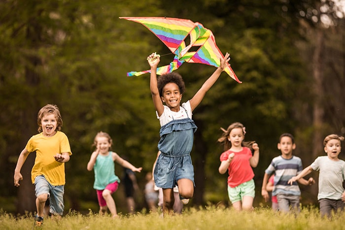 Group of kids running with a kite