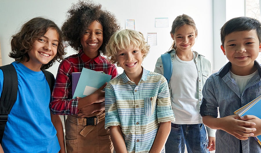 Group of kids holding notebooks posing for picture