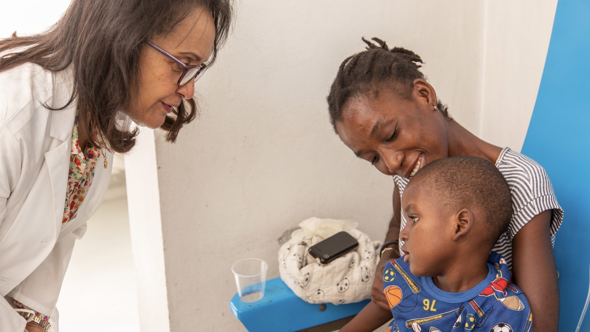 A healthcare provider talks to a mother and her young son.