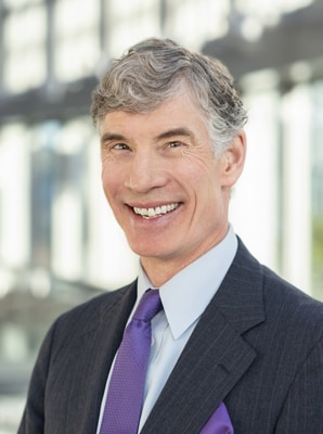 Dr. Salerno's headshot. He has short grey hair and is wearing a navy suit with a purple tie.