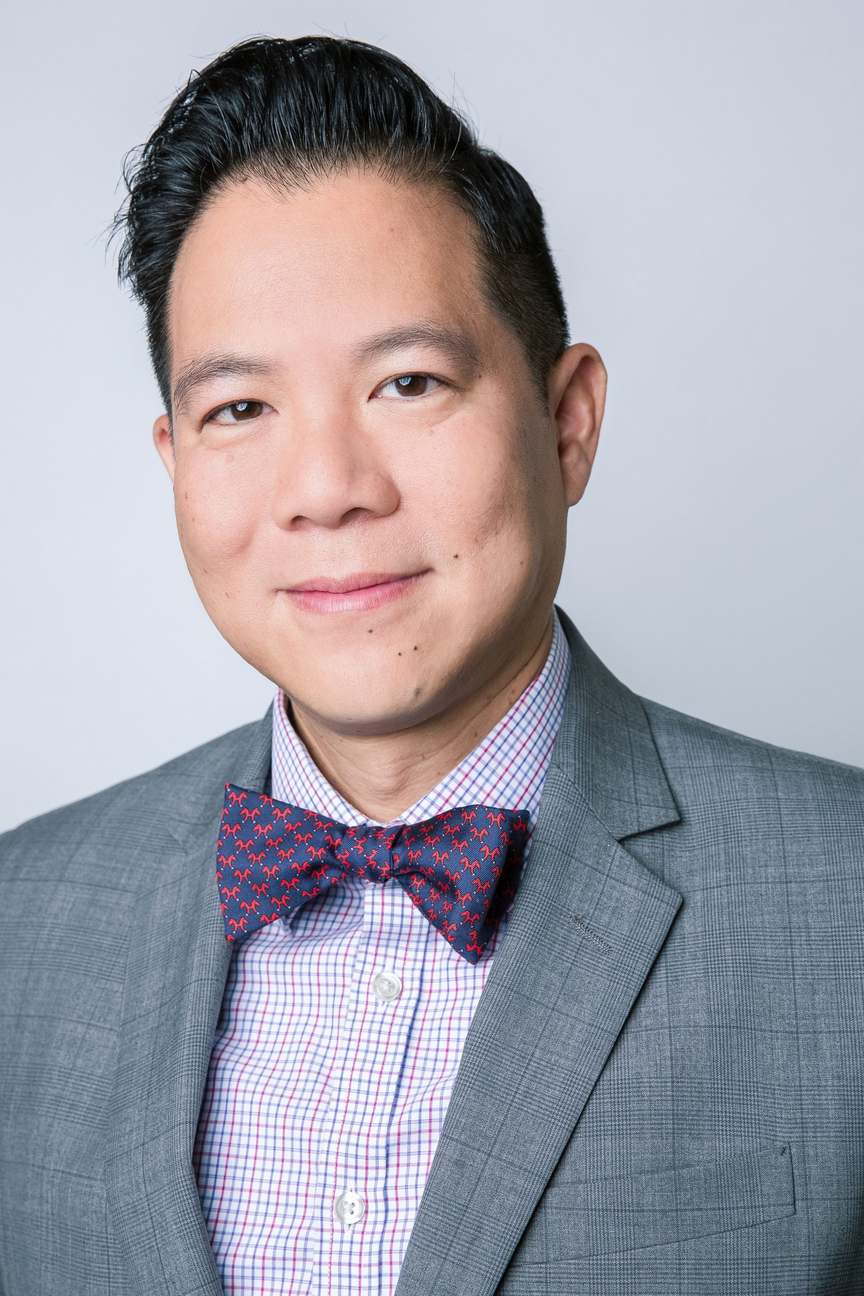 Profile picture of Dr. Anthony Nam Tran. Dark, short hair wearing a gray blazer with a purple bow tie.