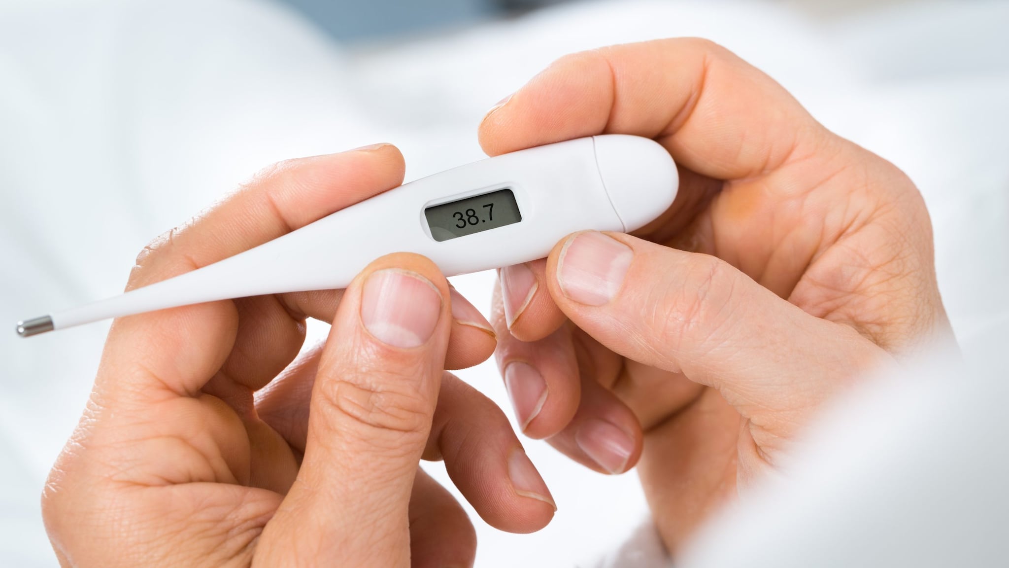 Pair of hands holding thermometer