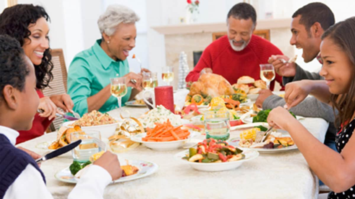 a family sitting at a dinner table and talking