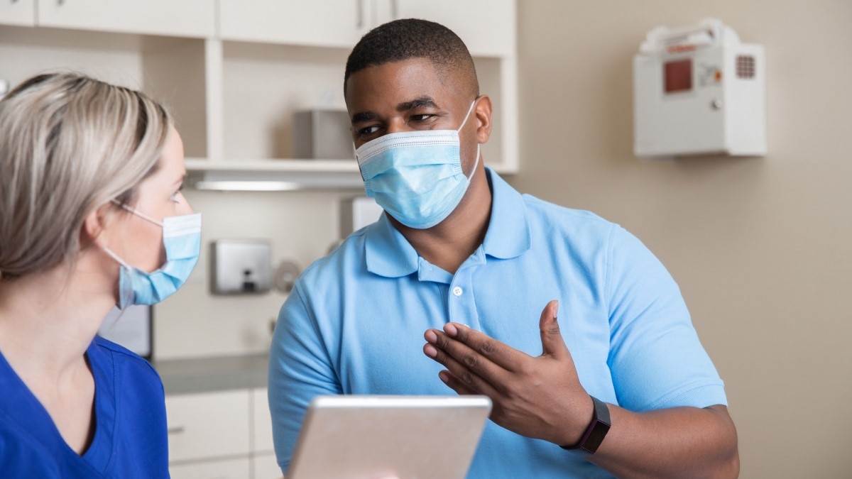 Photo of a man asking his doctor a question