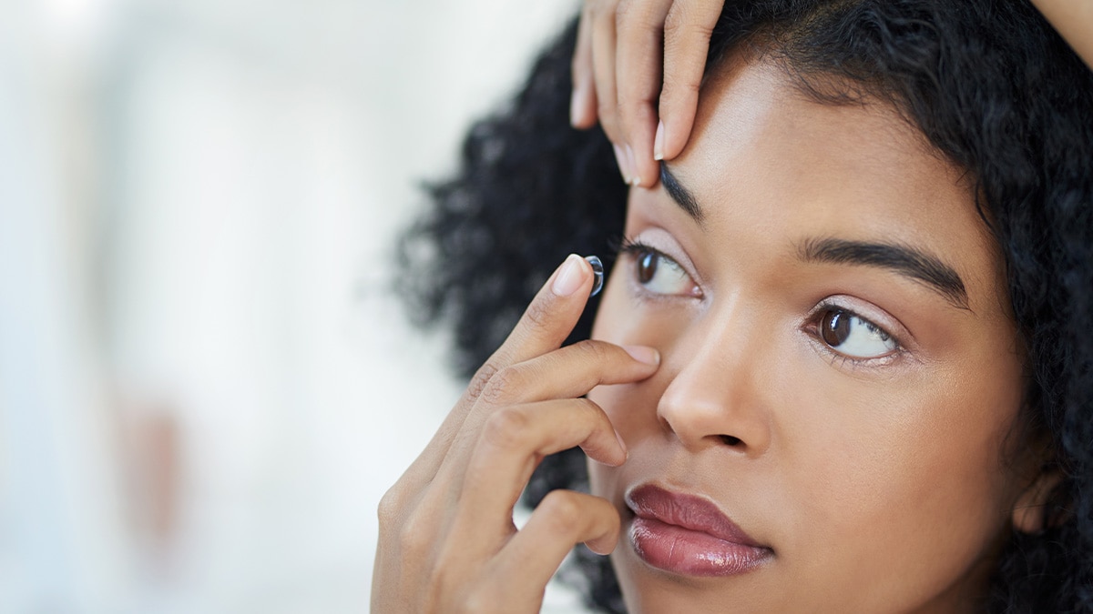 A woman putting on a contact lens.