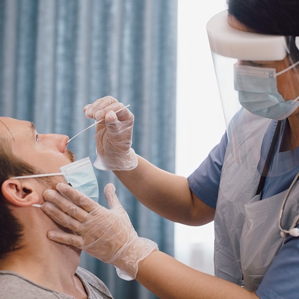 Healthcare provider taking nasal swab test of patient in clinic