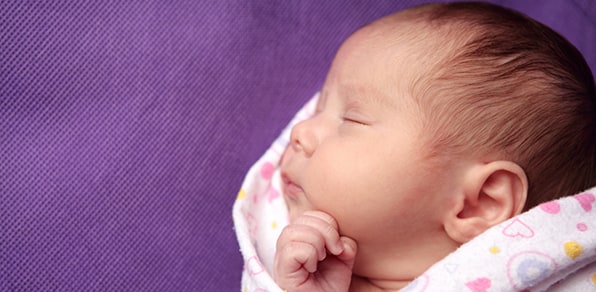 sleeping baby swaddled in blanket