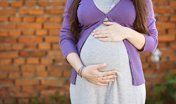 Pregnant mother holding belly.