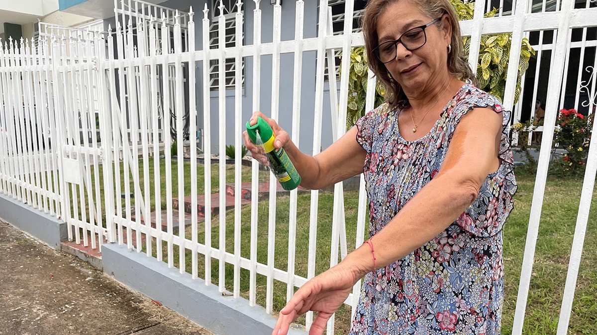 Woman applying insect repellent