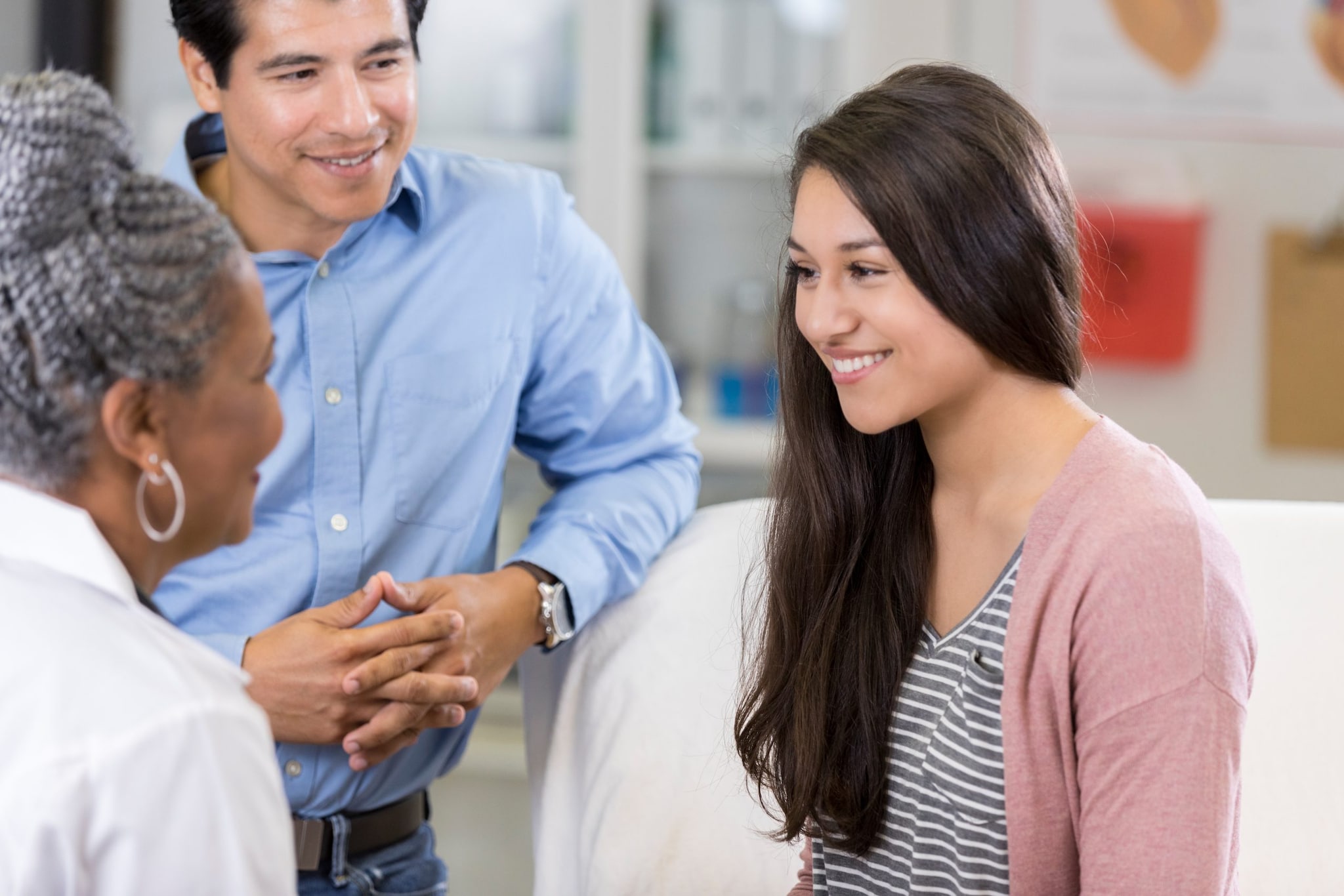 A healthcare provider providing a consultation to a pediatric patient and parent.