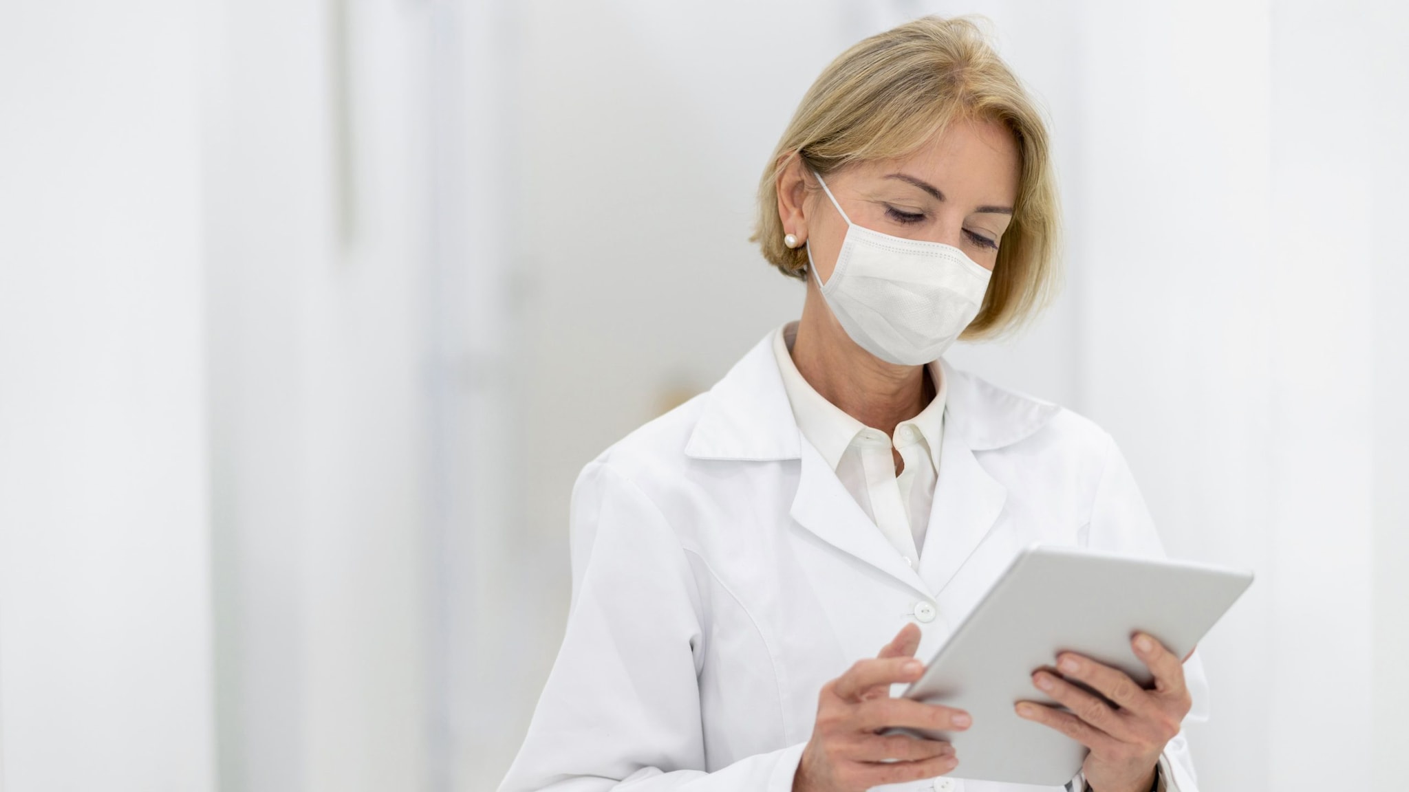 A female health care professional using a tablet.