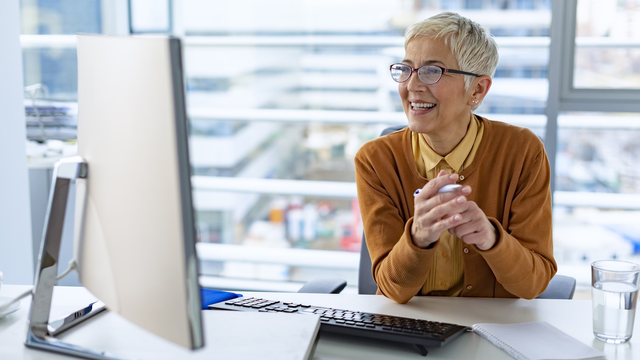 Business woman smiling and looking at her computer screen