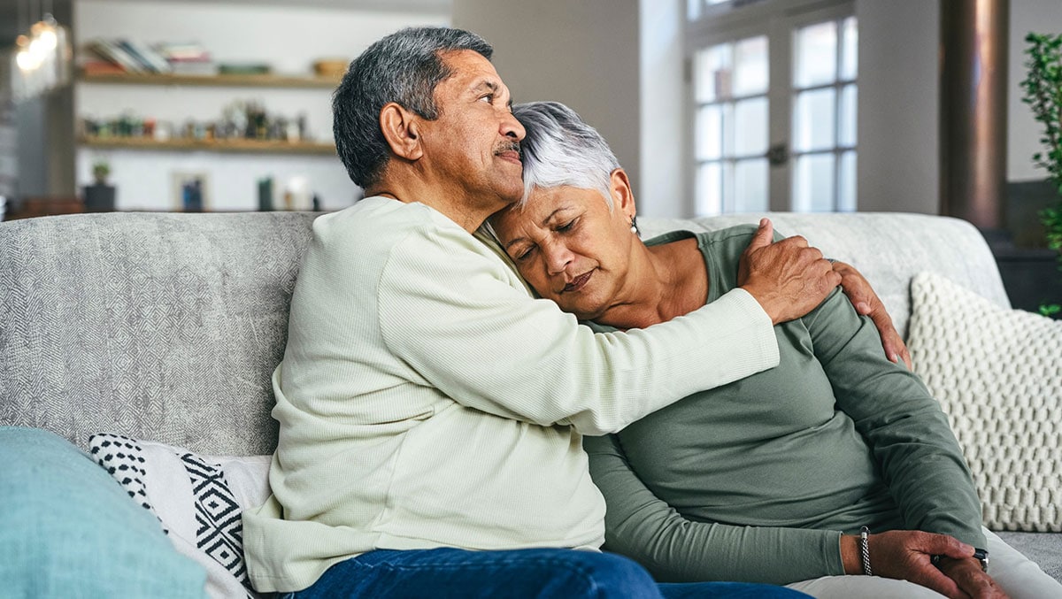 Hombre mayor apoyando a su esposa durante un momento difícil en su casa