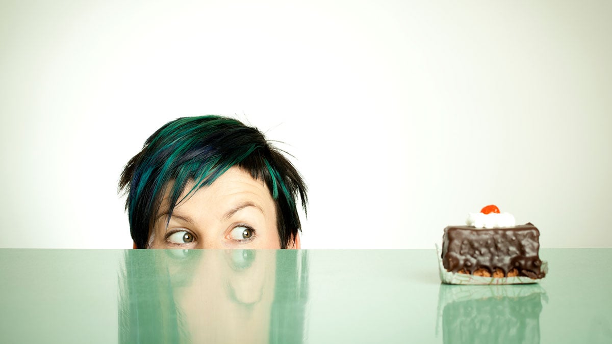 woman eyeing piece of cake