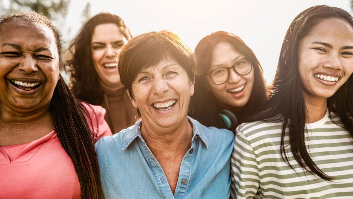 Grupo de mujeres diversas al aire libre sonriendo