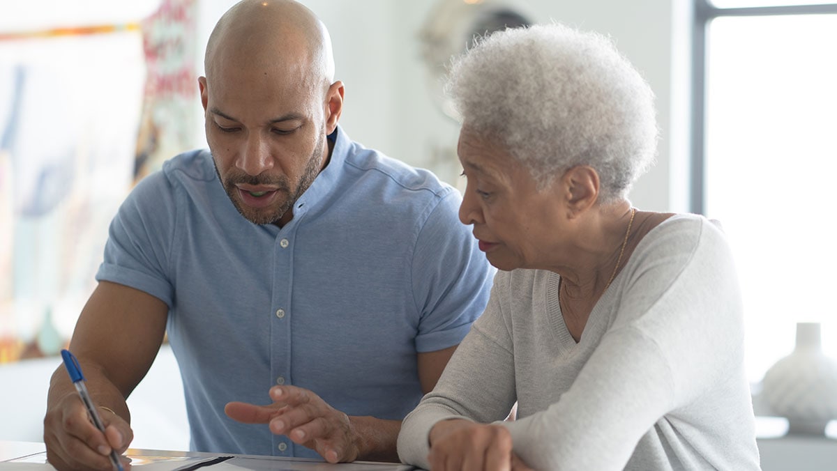 younger african american man working with older african american women