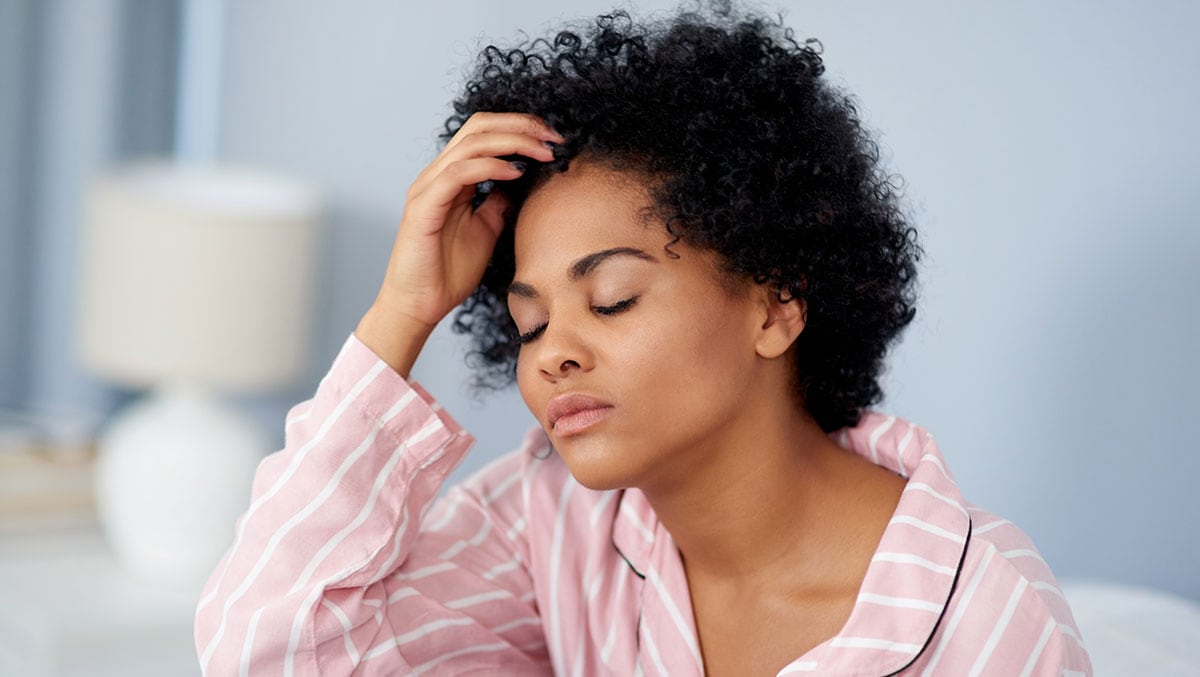 woman in pajamas looking stressed