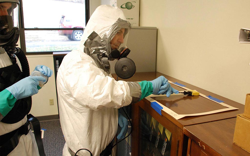 Health worker checking mailboxes for anthrax.