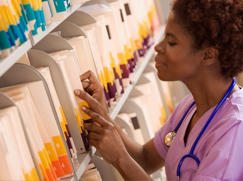 A nurse looking through patient files.