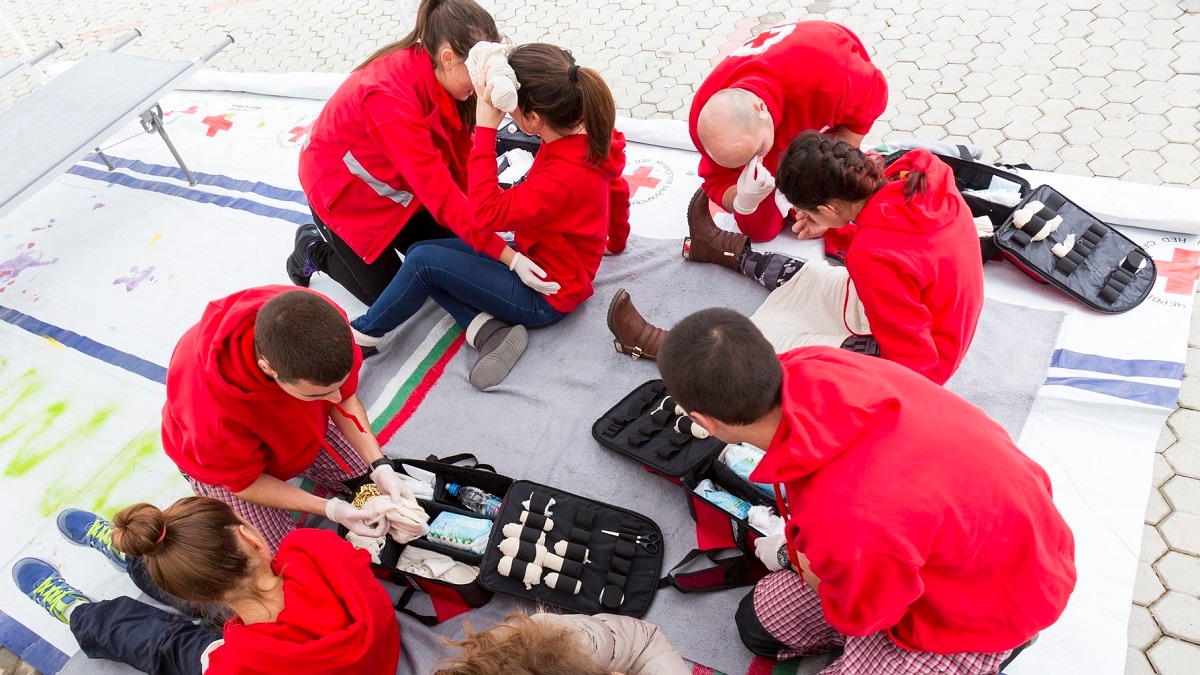 Group of first aid trainees practicing emergency care outdoors.