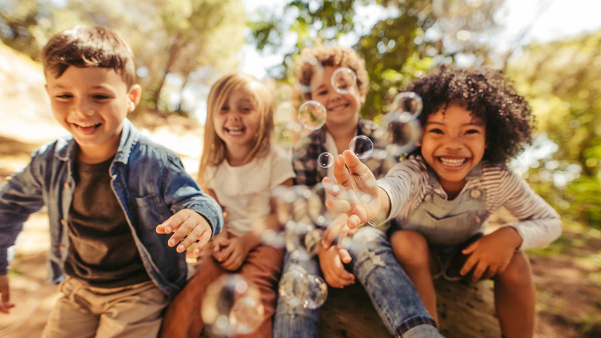 Group of young children blowing bubbles.