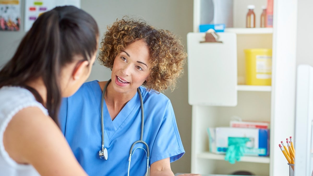 A woman speaks to a healthcare provider.