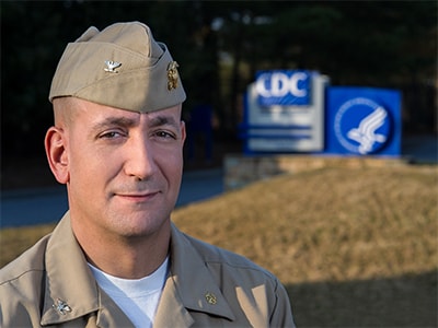 Doctor Eric Pevzner headshot in front of CDC headquarters sign